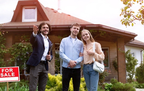 family in front of a for sale house
