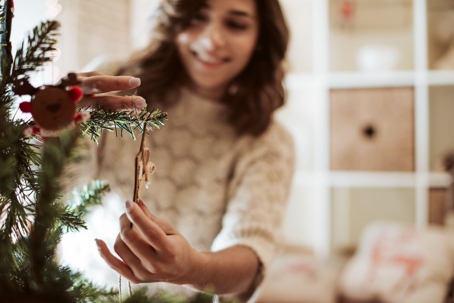 woman hangs a christmas ornament